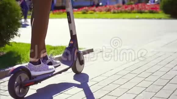 女孩骑着电动滑板车在城市附近移动视频的预览图