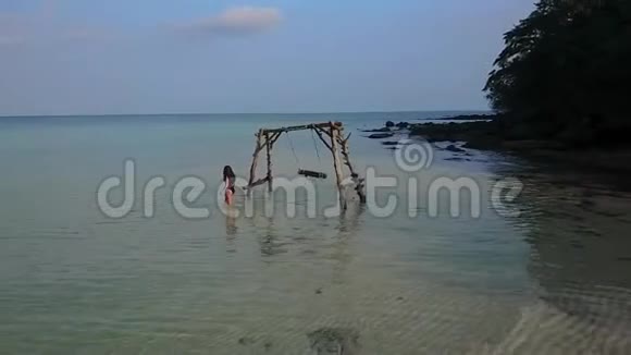 女孩在海中荡秋千水荡秋千失乐园无人居住的岛屿视频的预览图