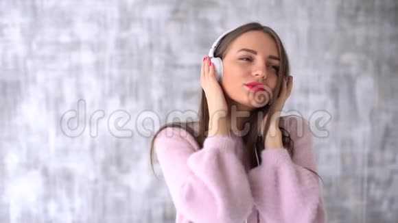 镜框里迷人的年轻女子长发女孩头上戴着白色的大耳机听音乐慢慢慢慢视频的预览图