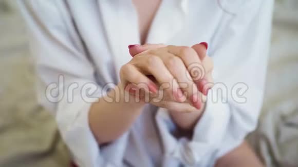 女性双手合拢漂亮的女人在她的手上涂化妆品奶油视频的预览图
