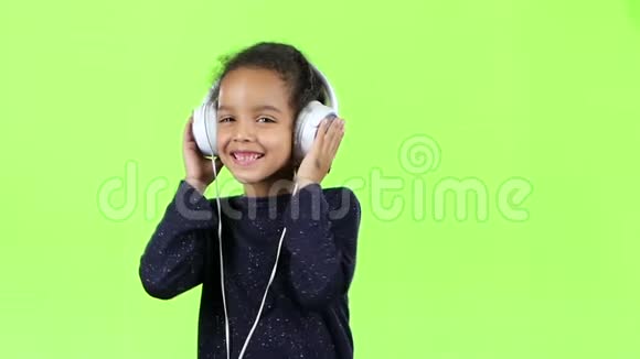 非裔美国人的孩子听着耳机里的音乐绿色屏幕慢动作视频的预览图