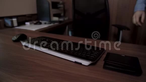 一个男人坐在桌子旁在键盘上输入文本然后用他的信用卡在线支付视频的预览图