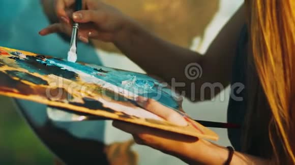 女人用手在木制调色板上混合油彩创意艺术家绘画视频的预览图