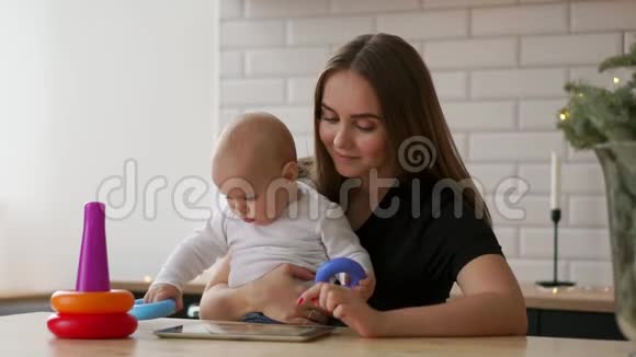 妈妈和宝宝想在家里的沙发上玩平板电脑视频的预览图