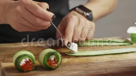 女性手工制作鱼子酱奶酪和黄瓜小吃卷视频的预览图