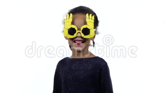 一个戴着滑稽眼镜跳舞的非裔美国女孩的孩子白色背景慢动作视频的预览图