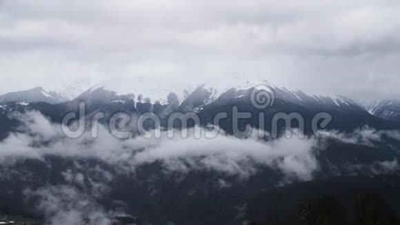 美丽的山峰和低云阴云密布的低天高悬的雪山视频的预览图