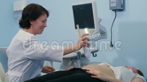 女医生给病人的胃涂上凝胶做超声波扫描视频的预览图