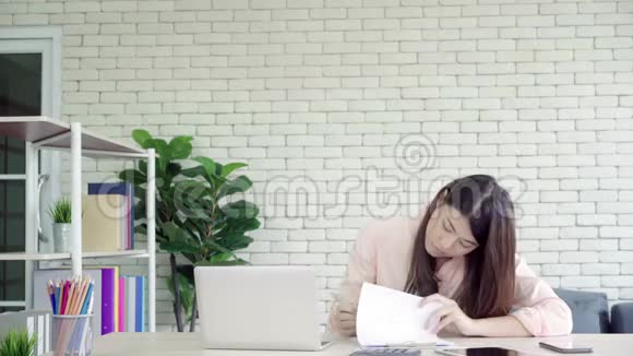 亚洲女商人给她的同事送咖啡她的同事正在办公室里用笔记本电脑视频的预览图