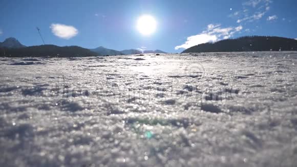 无法辨认的家伙在阳光明媚的冬日在雪地里慢跑一个年轻的男人在雪地草地上奔跑阳光和蓝天视频的预览图