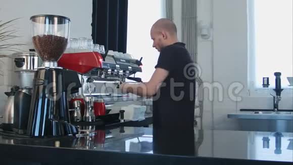 男咖啡师用咖啡机为客户准备咖啡视频的预览图