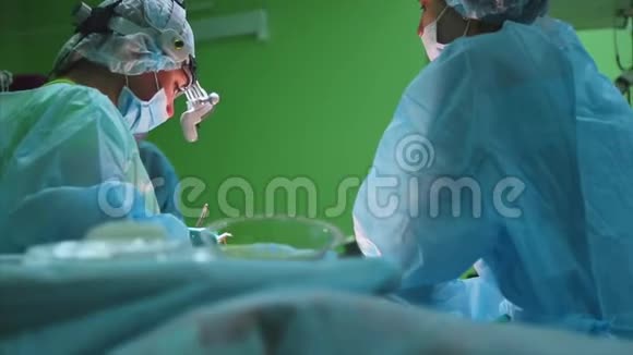 外科医生穿着防护服使用消毒设备进行手术医疗组执行外科视频的预览图