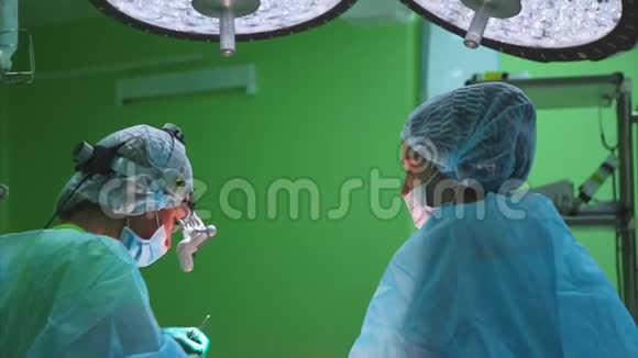 外科医生穿着防护服使用消毒设备进行手术医疗组执行外科视频的预览图