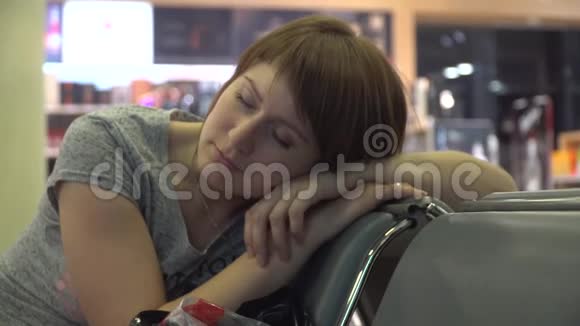 在机场等候区睡觉的女人航班延误视频的预览图