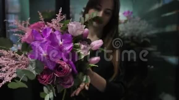 专业的女性花店用粉红色的郁金香玫瑰兰花和西兰花制作花束视频的预览图