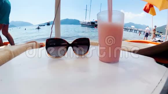 海边桌上的鸡尾酒和太阳镜特写慢动作视频视频的预览图