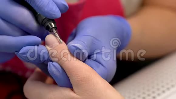 使用电动指甲钻机进行指甲角质和指甲抛光的特写五金干指甲视频的预览图