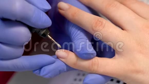用铣甲机进行指甲角质层去除和指甲抛光的特写五金修指甲视频的预览图