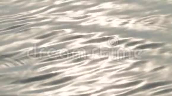 美丽的水波荡漾平静的波浪反射着五颜六色的日落光表面柔滑的水面背景视频的预览图