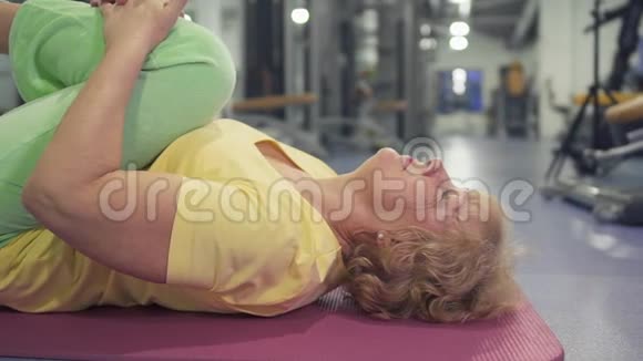 老年妇女在健身房里做腿部运动视频的预览图