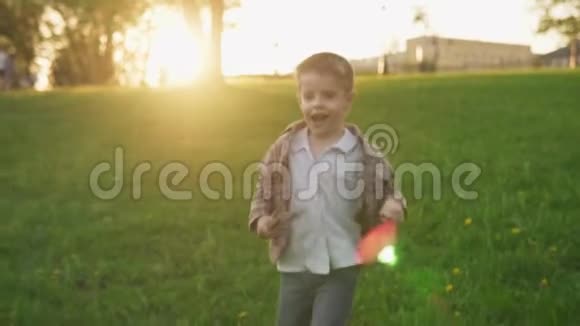日落时分在阳光明媚的夏日公园草坪上奔跑的儿童乐趣视频的预览图