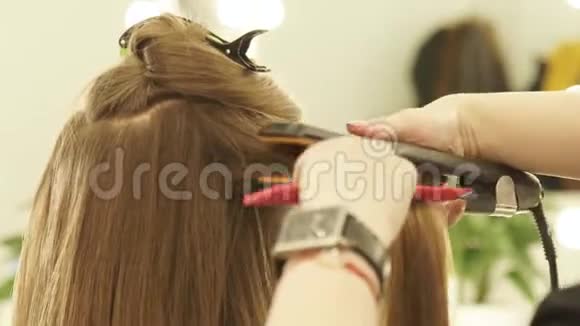 女理发师使用发钳和梳子在美容院理发整理发型师视频的预览图
