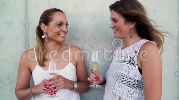 两个最漂亮的女朋友在聊天喝着起泡葡萄酒视频的预览图