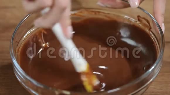融化的巧克力女性的手在碗里搅动融化的巧克力视频的预览图