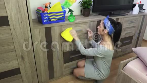 女人用黄色超细纤维清洁家具门视频的预览图