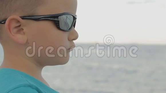 戴太阳镜的小孩看海视频的预览图