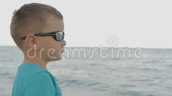 戴墨镜的男孩看着大海视频的预览图