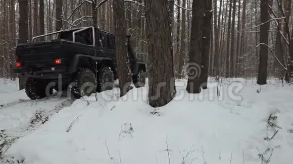 越野车6x6站在冬季森林覆盖雪的道路上后景视频的预览图