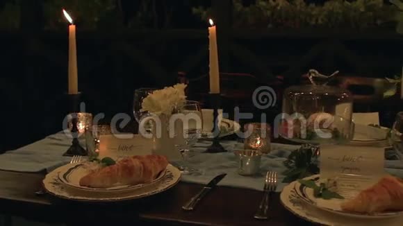 带餐牛角面包蜡烛马卡龙鲜花的慢盘假日餐桌视频的预览图