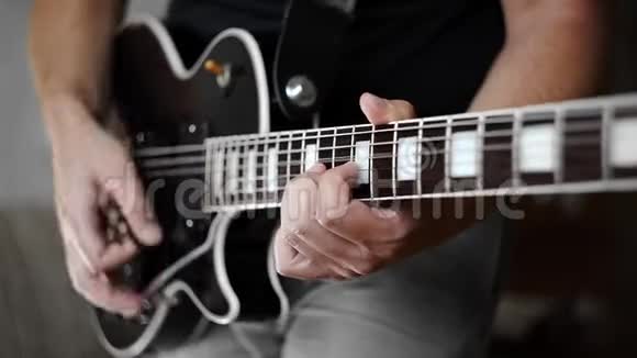 男人手用电吉他电乐器演奏时髦的节奏用吉他大声演奏摇滚视频的预览图