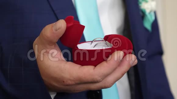 新郎手里拿着结婚戒指的盒子向他心爱的人求婚创造新的家庭特写视频的预览图