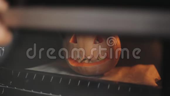 万圣节派对上雕刻的南瓜是在装满苹果的烤箱里烤的特写视频的预览图