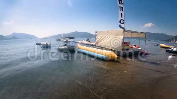 充气香蕉滑板车和停泊在海上浮桥的船只的4k镜头视频的预览图