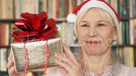 有礼物的高级女人戴红帽子带红丝带礼盒的退休人员庆祝圣诞节视频的预览图
