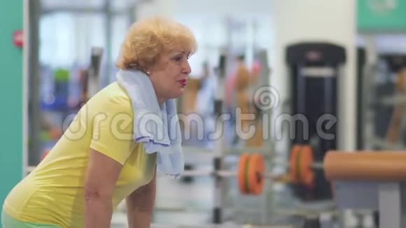 老年妇女在健身房用杠铃做运动视频的预览图
