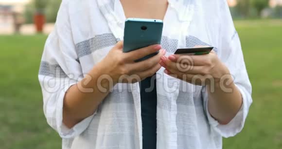 年轻的高加索人用她的信用卡在她的智能手机上从互联网上购买商品视频的预览图