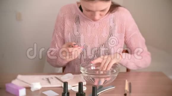 家里的手法女人把手伸进一碗水里手术工具放在桌子上视频的预览图