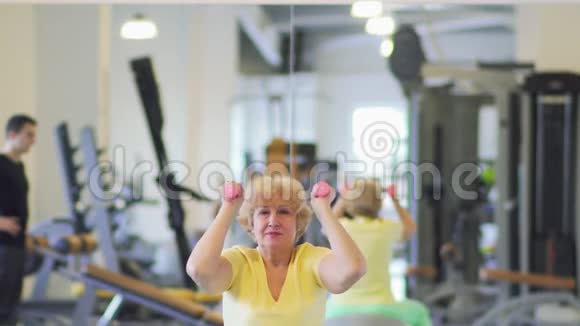 奶奶在健身房用杠铃做运动视频的预览图
