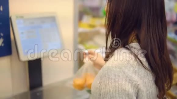 一家超市蔬菜部的年轻女子体重为橘子视频的预览图
