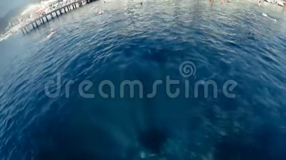 慢动作POV画面中的年轻人从浮舟上跳下来在水下潜水视频的预览图