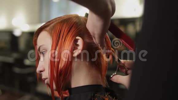 男理发师在美容院剪女头发年轻女子剪头发穿发廊视频的预览图