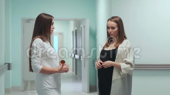 站在围产中心走廊的孕妇与女医生沟通视频的预览图