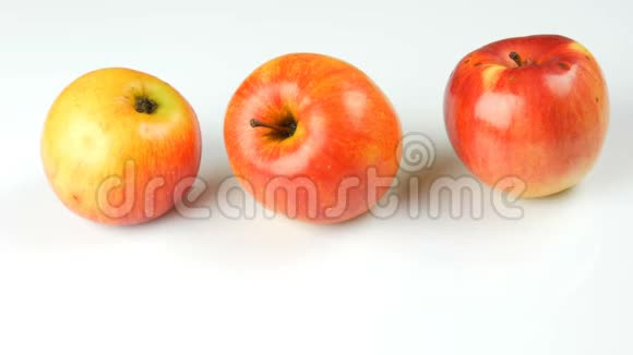 雌性手拿着成熟多汁和新鲜的苹果把成熟的腐烂变质的苹果放在白色的背景上视频的预览图