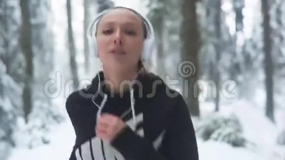 冬季寒冷森林中的女跑步者慢跑视频的预览图