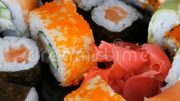 各种彩色寿司卷集和生姜在镜面上的黑色背景日本料理工作室视频的预览图