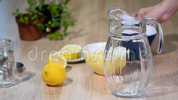 用柠檬和薄荷在一个小厨房的玻璃瓶中准备柠檬水视频的预览图